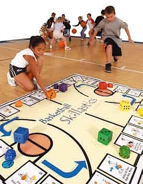 Kinder spielen ein Brettspiel mit Basketball-Trainingselementen auf dem Boden einer Turnhalle.
