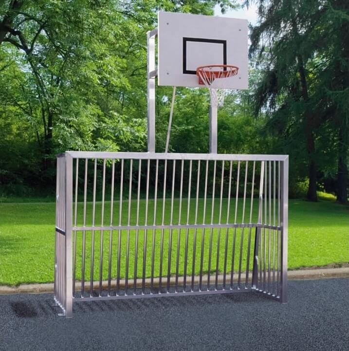Ein kombinierter Basketballkorb und Tor aus Metall in einem grünen Park.