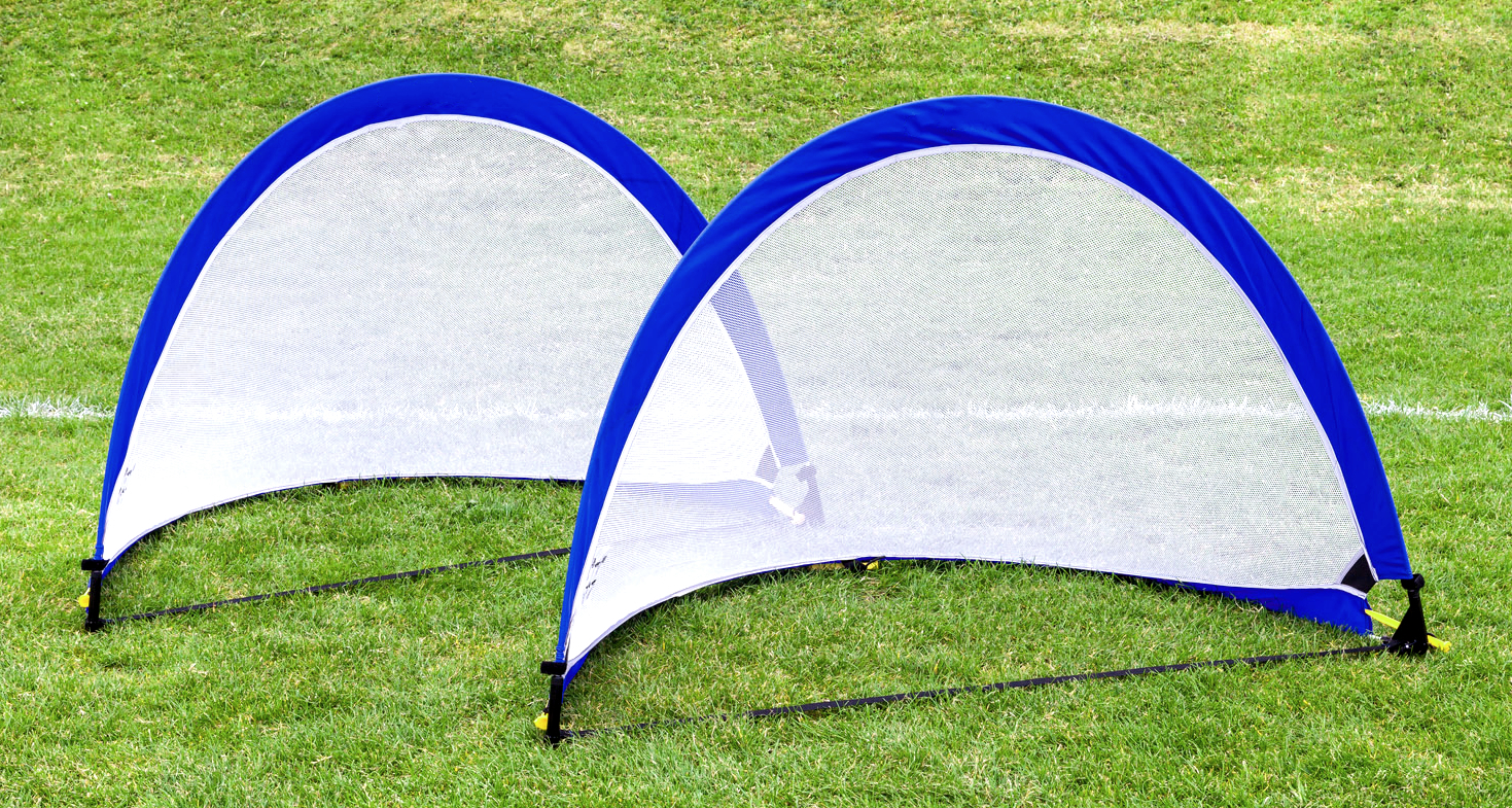 Zwei zusammenklappbare blaue Pop-up-Fußballtore auf einer Wiese